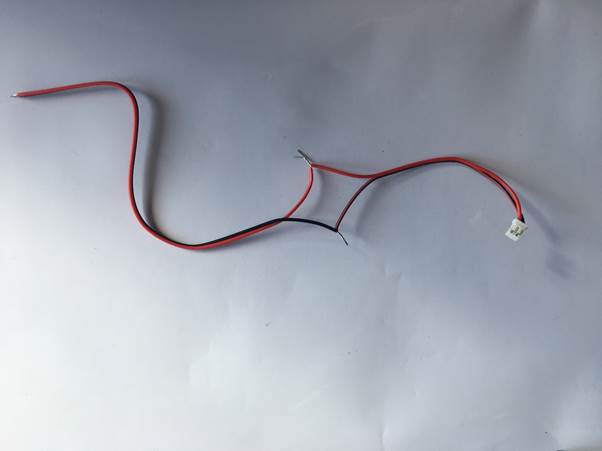 Two stripped electrical wires, one black and one red, connected to a small white connector.