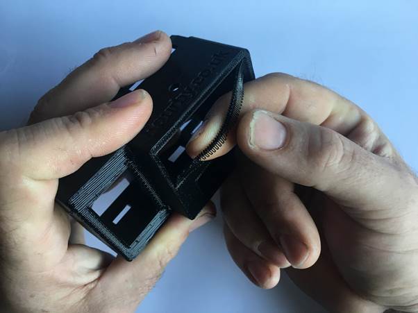 Person's hands removing the support material from a 3D printed multifunction clock kit.