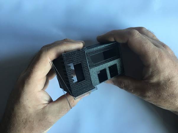 A person holding a 3D printed Fourby Multifunction USB clock kit, showing its front and side details.