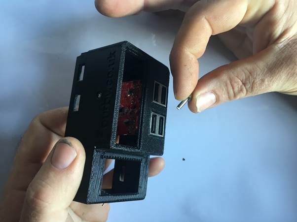 Person holding a Fourby Multifunction USB clock case and a screw, preparing to assemble the clock.