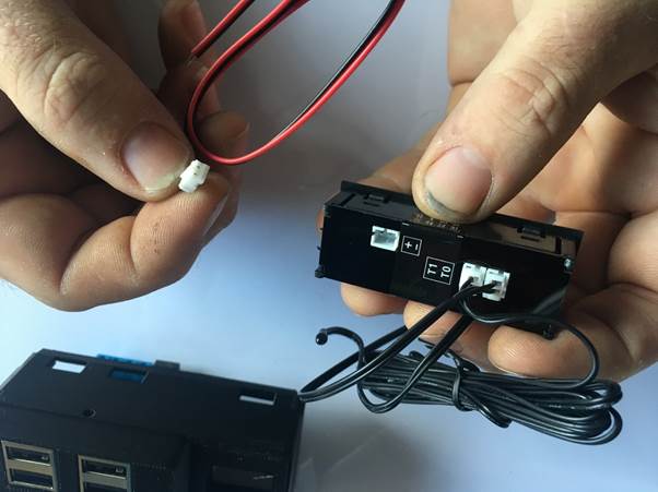 Hands holding a USB module with wires, preparing to connect the colored wires to the module.