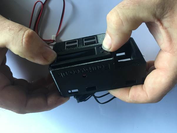 Hands assembling the Fourby multifunction USB clock, ensuring proper alignment of the components.