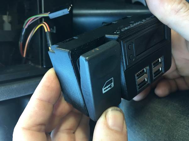 Person holding the Fourby USB clock module and switch, preparing for installation.